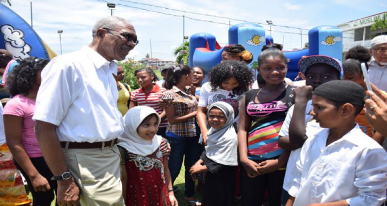 President David Granger interacting with a group of children who attended the annual CIOG Fun Day at its Woolford Avenue headquarters on Thomas Lands on Saturday