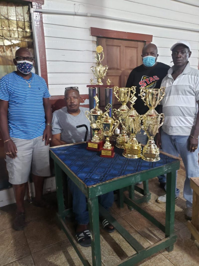 From left are organiser Orin Boston, Georgetown Dominoes Association president Colin McEwan, Dhyan Carter and Mark Wiltshire with the trophies.