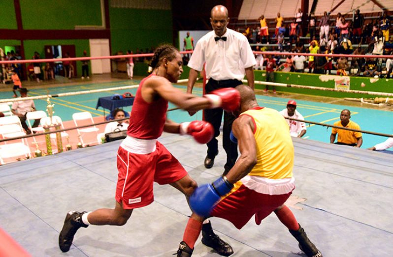Best Boxer Keevin Allicock (left) of FYF gym connects to the head of GDF’s Clairmont Gibson in their bantamweight contest, flooring him (Gibson) in the process. (Adrian Narine photo)