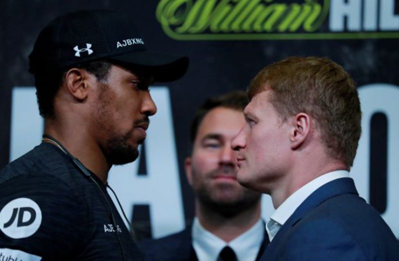 Anthony Joshua and Alexander Povetkin go head-to-head as promoter Eddie Hearn looks on. (Action Images via Reuters/Andrew Couldridge)