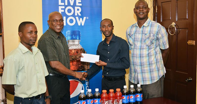 L-R, GBA Youth coach Seibert Blake watches on as GBA president Steve Ninvalle gladly accepts the sponsorship cheque from DDL’s brand executive Larry Wills. GBA TD Terrence Poole also looks on. (Samuel Maughn photo)