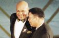 Former boxing champions George Foreman, left, and Muhammad Ali on stage at the 69th annual Academy Awards, in 1997.