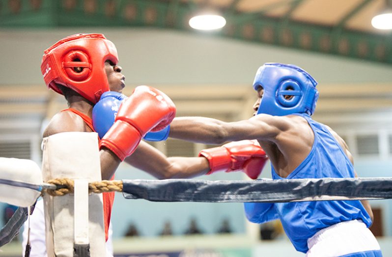Guyana’s Mark Crawford (left) connects with a series of combinations to Barbados’ Reshawn Holder in their lightweight bout in the Juniors category of the Caribbean Boxing Championship at the Cliff Anderson Sports Hall on Thursday night (Photo by Delano Williams)