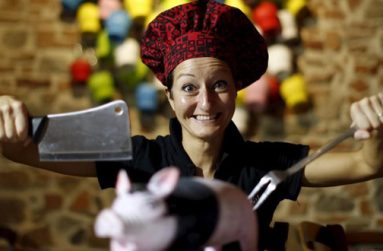 Italian chef Cristina Palanti poses with a meat cleaver and cooking fork hovering over a plastic pig figurine at the "L'e'Maiala" restaurant in Florence in this October 6, 2012 file photo. (REUTERS/Alessandro Bianchi/files)