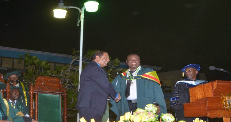 Prime Minister Moses Nagamootoo shakes the hand of recipient of the 2015 Prime Minister’s Medal for best graduating student in Public Management, Superintendent of Police Brian Eastman