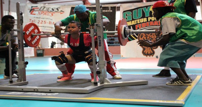 Female Best Lifter Britney Mack is watched by spotters during the squat.