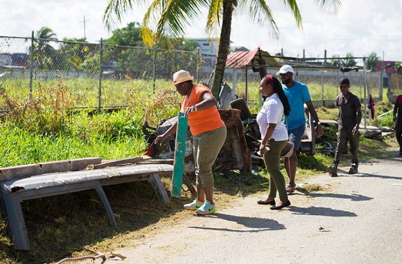 Residents cleaning the parameters of the community centre ground (Delano Williams photo)