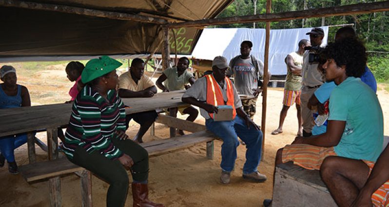 Minister Broomes in discussion with the miners at Konawaruk Backdam in the presence of  GGMC officials.