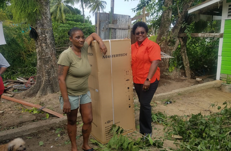 Lukesha Hackett with Minister Broomes after receiving her new refrigerator