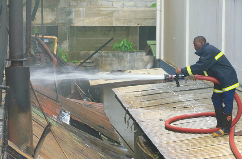 A fireman battles to quell a fire at the southern side of the premises on Saturday