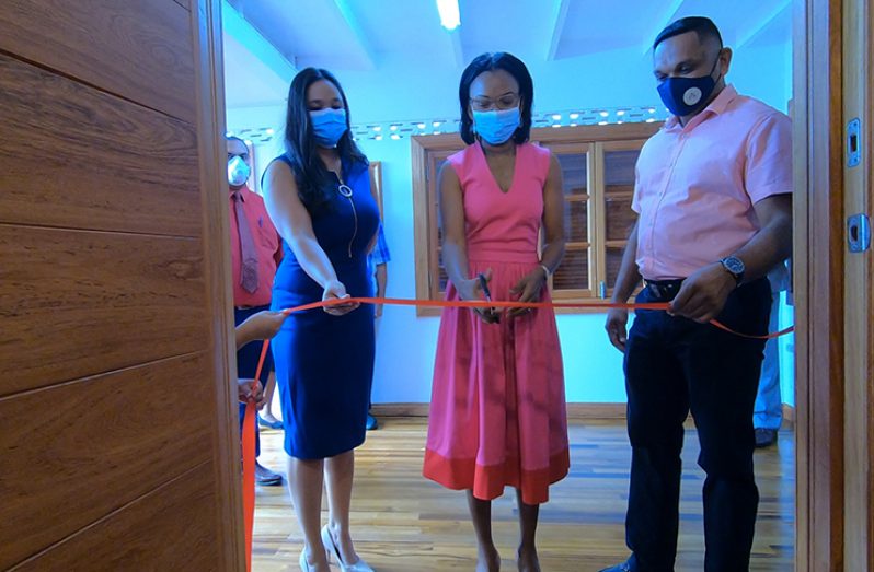 Minister of Tourism, Industry and Commerce, Oneidge Walrond (centre), cuts the traditional ribbon to officially declare open the showroom. Helping her do the honours are Minister of Natural Resources, Vickram Bharrat (right), and Showroom Manager, Roseann Bulkan (left)