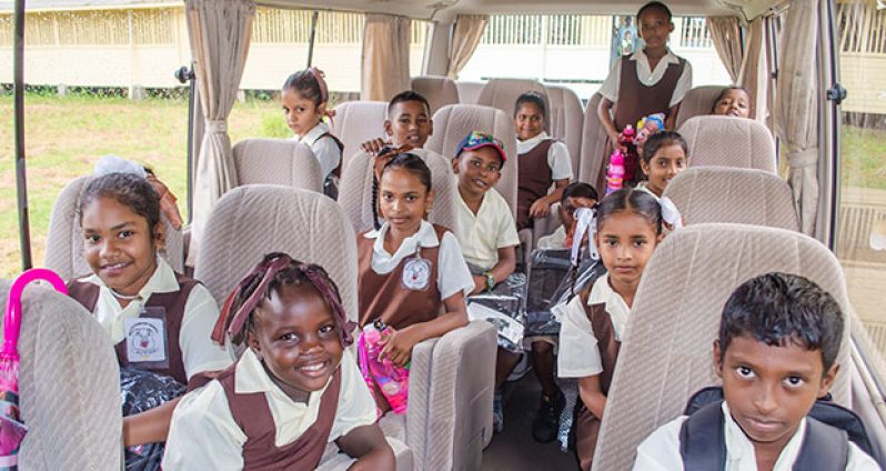 Students of Wales Primary take first ride on the bus handed over on Wednesday. (Adrian Persaud/Department of Public Information photo)