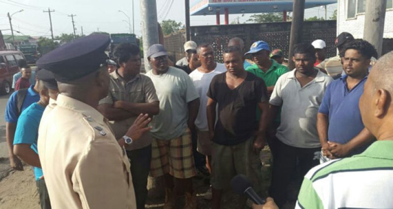 Traffic Chief Ian Amsterdam interacting with truck drivers at New Hope Public Road, East Bank Demerara, yesterday morning