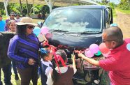 A student cuts the ceremonial ribbon as Regional Chairperson Vilma Da Silva officially hands over the buses