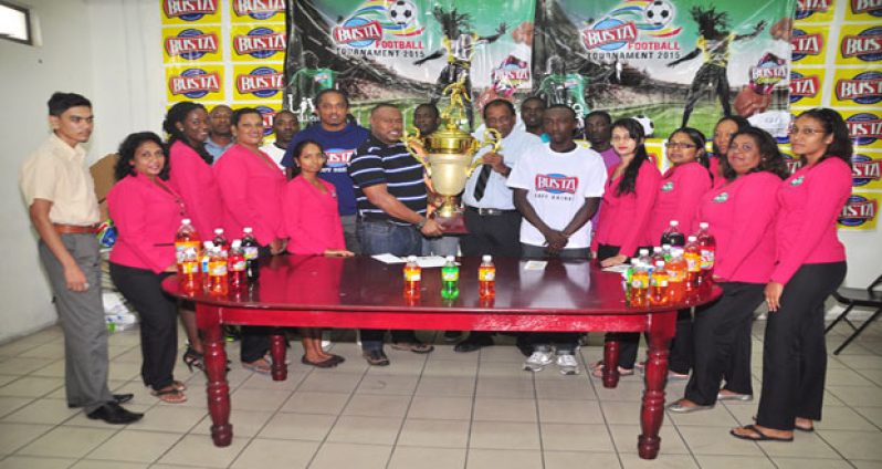 Guyana Beverage Company Managing Director Robert Selman hands over the winning trophy for the inaugural ‘Busta Soft Shoe Football’ tournament to Petra Organisation’s Troy Mendonca yesterday.