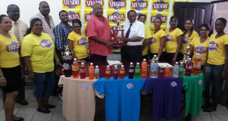 Flanked by the Busta Girls and members of staff of both the Guyana Beverage Company Inc. and Rose Hall Town Youth and Sports Club, a smiling Robert Selman (7th from right) presents the cheque to Hilbert Foster.