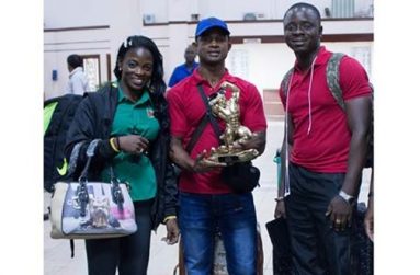 The ‘golden boy’ Devon Davis (centre) is flanked by Alisha Fortune and GABBFF president Keavon Bess, following their arrival at the Cheddi Jagan International Airport yesterday morning.