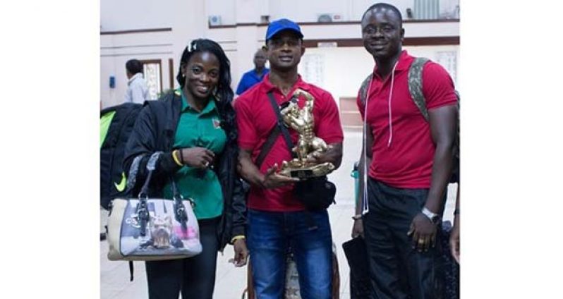 The ‘golden boy’ Devon Davis (centre) is flanked by Alisha Fortune and GABBFF president Keavon Bess, following their arrival at the Cheddi Jagan International Airport yesterday morning.