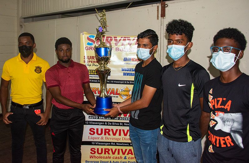 Some of the captains of the teams who will be competing pose with the GCA-Ramchand Auto Spares/Survival Group/Trophy Stall U-19 50-Overs Tournament Trophy