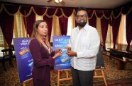 President Dr Irfaan Ali displays the newly rebranded debit card designs of the Guyana Bank for Trade and Industry (GBTI) during an engagement with a team from the bank at State House