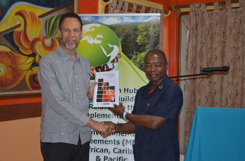 Programme Coordinator Dr. Patrick Chesney hands over a copy of “The State of Biodiversity in the Caribbean – A review of progress towards the Aichi biodiversity targets” to CARICOM Assistant-Secretary General, Ambassador Colin Granderson (Rabindra Rooplall photo)