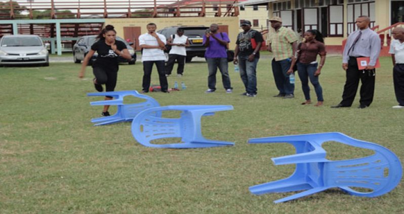 CASTLIN SHOWS: U.S. 100m hurdler Kristi Castlin demonstrates hurdle drills for coaches. Second right is AAG president Aubrey Hutson.