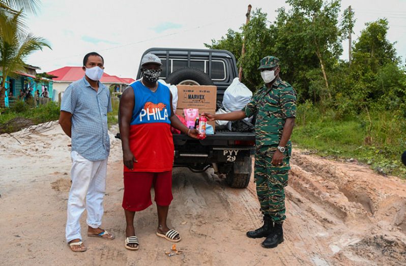 Director- General of the Civil Defence Commission (CDC) Lt. Col. Kester Craig hands over hampers to District Community Development Officer, Region 10, Byron Kendall.