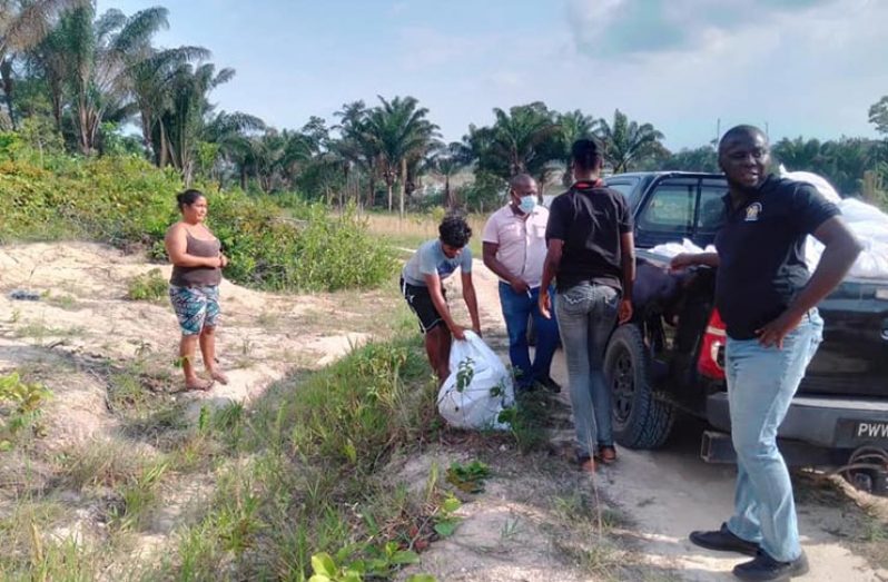 CDC representatives distributing hampers to residents of communities in Region 10 on Wednesday (CDC photo)