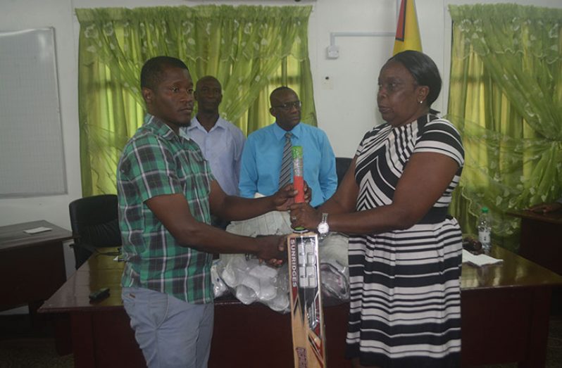 Chairman of the Region 10 RDC’s Education Committee Denise Belgrave handing over a quantity of cricket gear to Ituni CDC Chairman, Kurt Murphy, in the presence of Regional Chairman Renis Morian and Deputy Regional Chairman, Elroy Adolph.