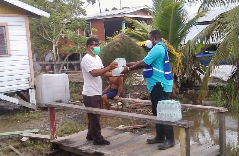 A resident of Charity collects his relief supplies from a CDC official