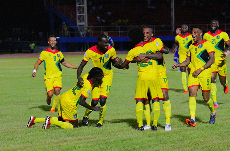 Trayon Bobb (#20) being swarmed by his ‘Golden Jaguars teammates after scoring the opening goal of the Guyana vs Barbados encounter during the CONCACAF Nations League (Samuel Maughn photos)