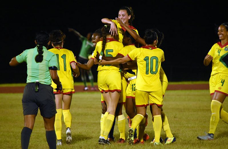 Brianne Dessa (#15) is swarmed by her teammates after scoring Guyana’s equalizing goal against Bermuda. The two sides played to a 2 – 2 draw.