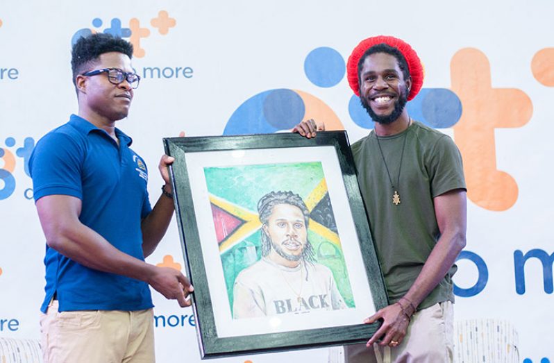 University of Guyana student and artist Michael Griffith, presented Chronixx with a portrait during his visit to the Turkeyen Campus on Friday. (Delano Williams photos)