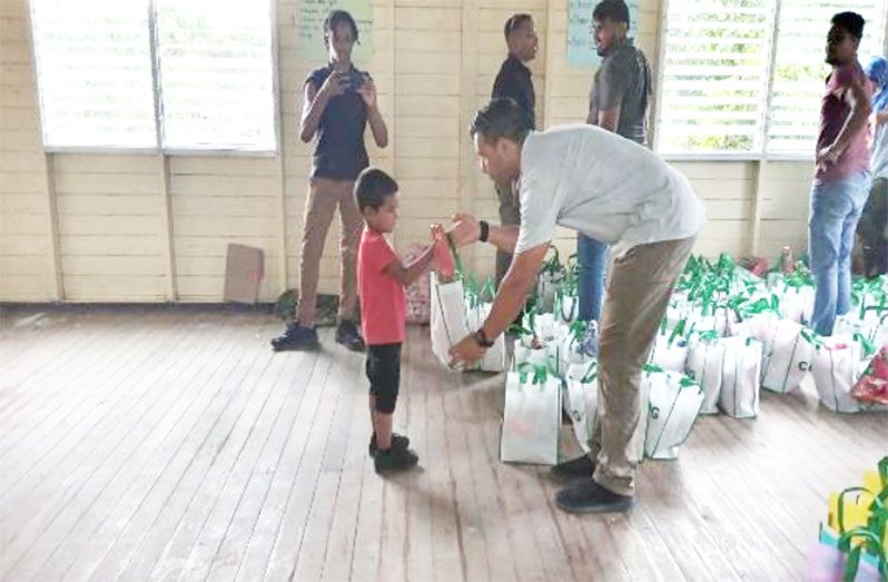 A Central Islamic Organisation of Guyana (CIOG) representative handing over gifts to a child