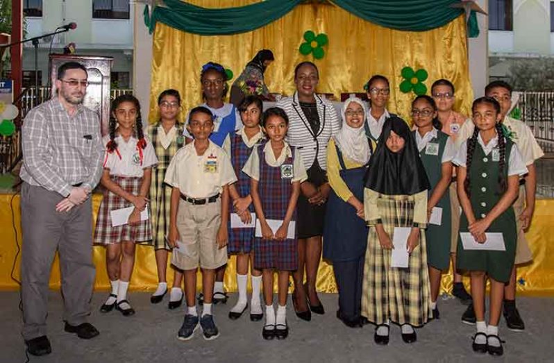Extreme left, CIOG’s Director of Education, Shaykh Moen-ul-Hack;  Minister of Education Nicolette Henry (centre), and 13 of the top 20 NGSA students