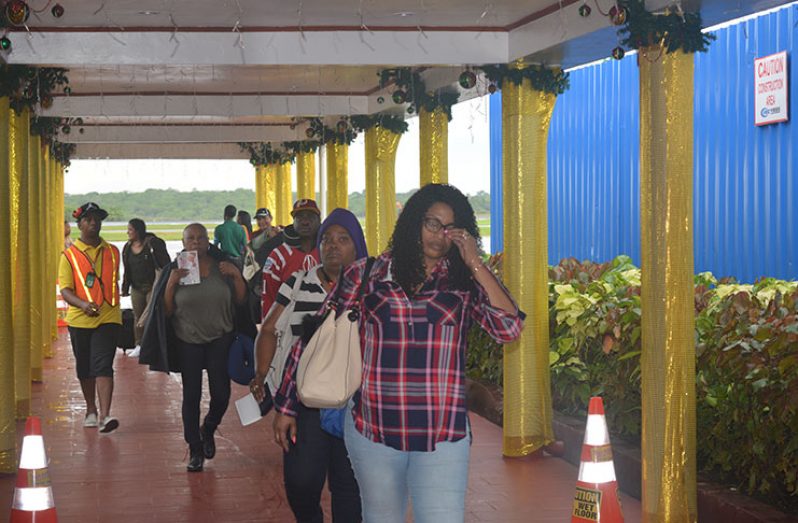 Some of the disgruntled Dynamic Airways
passengers making their way through the
Arrival area at the Cheddi Jagan International
Airport. Many of the passengers were
stranded for several days at the JFK Airport