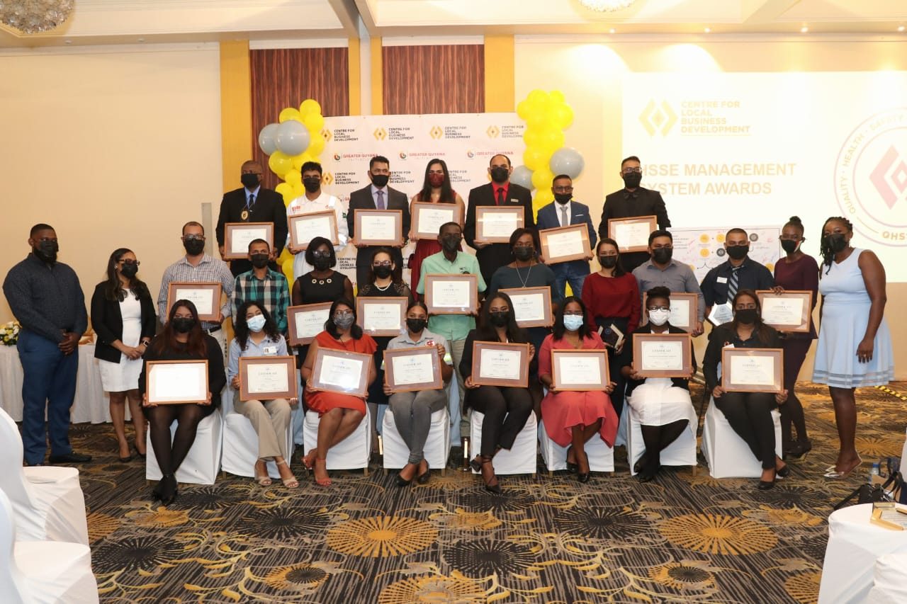 Representatives of participating businesses display their certificates, flanked by Senior Quality HSSE Officer, Akil Lewis (far left), CLBD Director, Natasha Gaskin-Peters (second from left), and CLBD HSSE Coordinator, Lavonia Springer (far right)