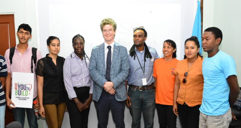 British High Commissioner Greg Quinn (centre) and Habitat for Humanity’s National Director Rawle Small (fourth right), stand with a group of volunteers for the Climate Smart Project on Thursday
