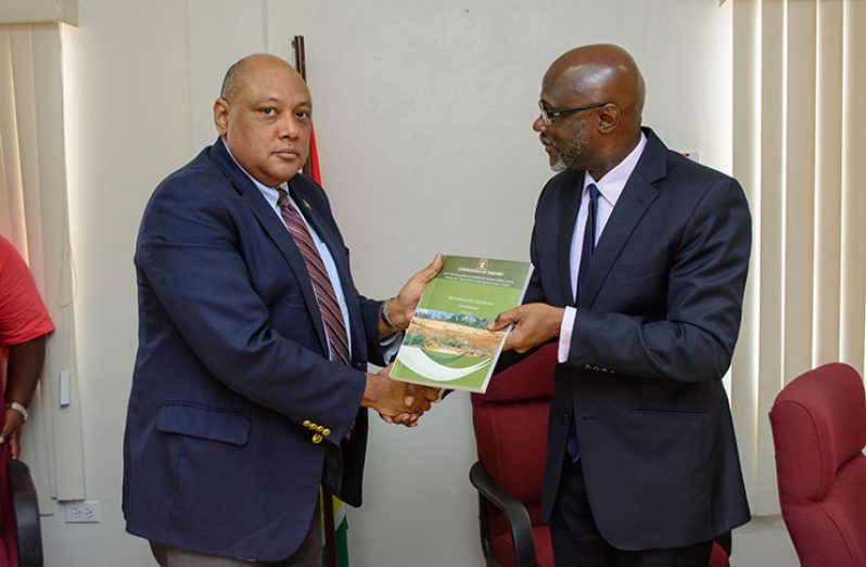 Rear Admiral Gary Best hands over the interim report to Minister of Natural Resources Raphael Trotman on Wednesday