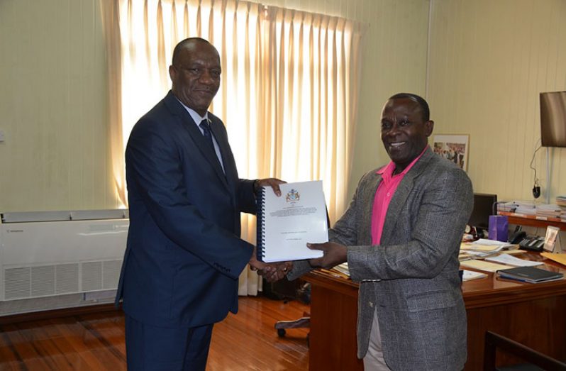 Brigadier (Ret'd) Edward Collins, Commissioner of the Commission of Inquiry, hands over the report pertaining to the discovery of an aircraft near the village of Yupukari, Upper Essequibo-Upper Takutu to Minister of State, Mr. Joseph Harmon