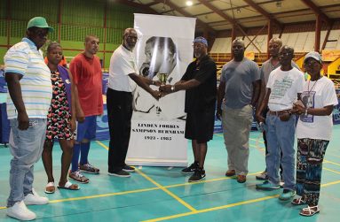 Former National Table Tennis Champion Colin France (centre, right) collects his trophy from a member of the Burnham Foundation.