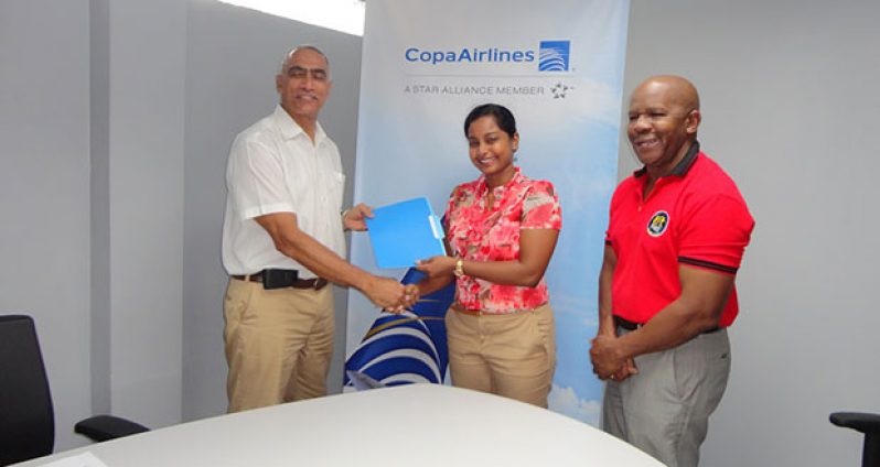– Copa Airlines Country Sales Manager Nadine Oudkerk presents to David Gomes ‘A Letter of Commitment’ for their new partnership. At right is Director of Flex Night Inc. Donald Sinclair