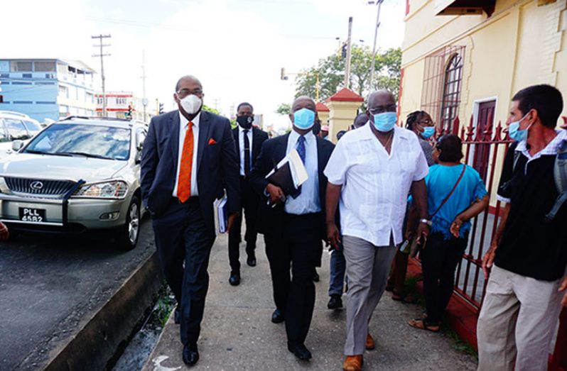 Chief Elections Officer (CEO), Keith Lowenfield (first right) approaches the Georgetown Magistrates’ Court with his lawyers Senior Counsel Neil Boston (centre) and Attorney-at-Law Nigel Hughes (Carl Croker photo)