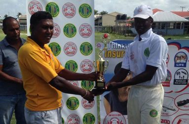 Kevin Sinclair collects the man-of-the-match trophy from president of the Enterprise Busta Sports Club, Seemangal Yadram.