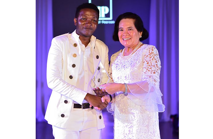 Quinton Pearson receives the Award
of Excellence Fashion Innovation
from the First Lady of Guyana, H.E.
Sandra Granger at the 2018 Caribbean
Style and Culture Awards and
Fashion Showcase in Maryland, USA
(Photo by Brandon Norwood)