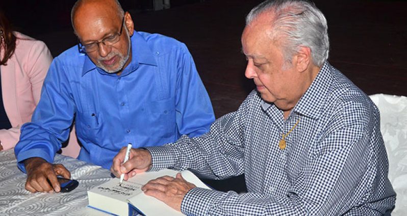 President Donald Ramotar receives his autographed copy of ‘Glimpses of a Global Life’ from Sir Shridath Ramphal last evening