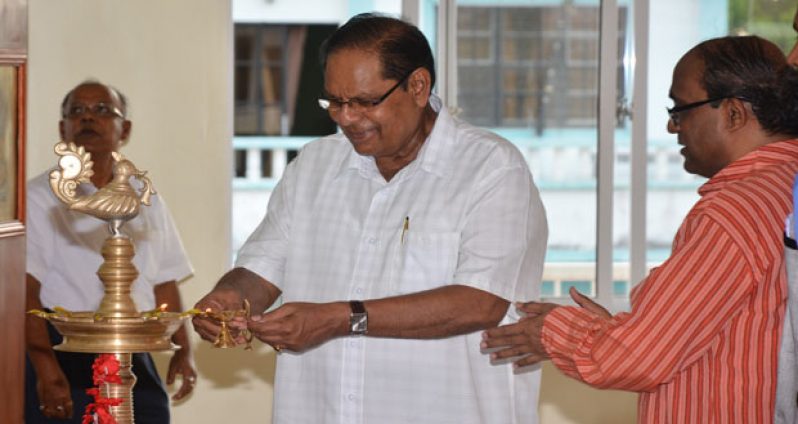 Prime Minister Moses Nagamootoo lighting the lamp before commencement of the Yoga event on Sunday. In photo, at right, is Indian High Commissioner to Guyana, Mr V. Mahalingham