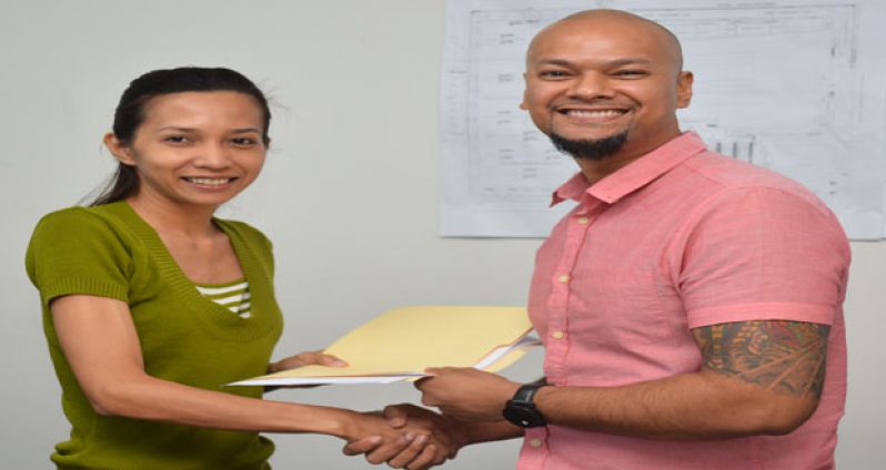 Marketing Manager of Giftland, Karen Agtarap hands over the agreement to ‘Publik Wing and Burger House’ owner Sean Major, yesterday (Samuel Maughn photo)