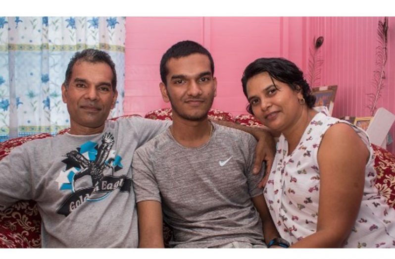Manoj Lachhman [centre] with his parents.
