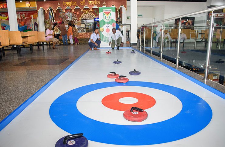 Curling, a game usually played on ice, was
introduced on Tuesday for the first time at the
Giftland Mall, by the Guyana Curling Federation.
Chronicle Sport’s reporter Rawle Toney (right)
gives the game a try. (Samuel Maughn Photo)